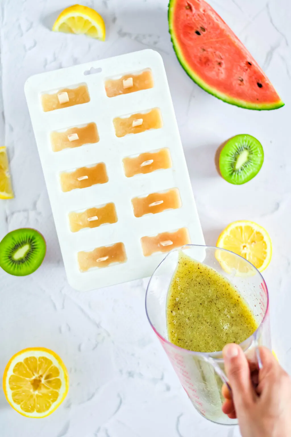 pouring kiwi puree into popsicle molds