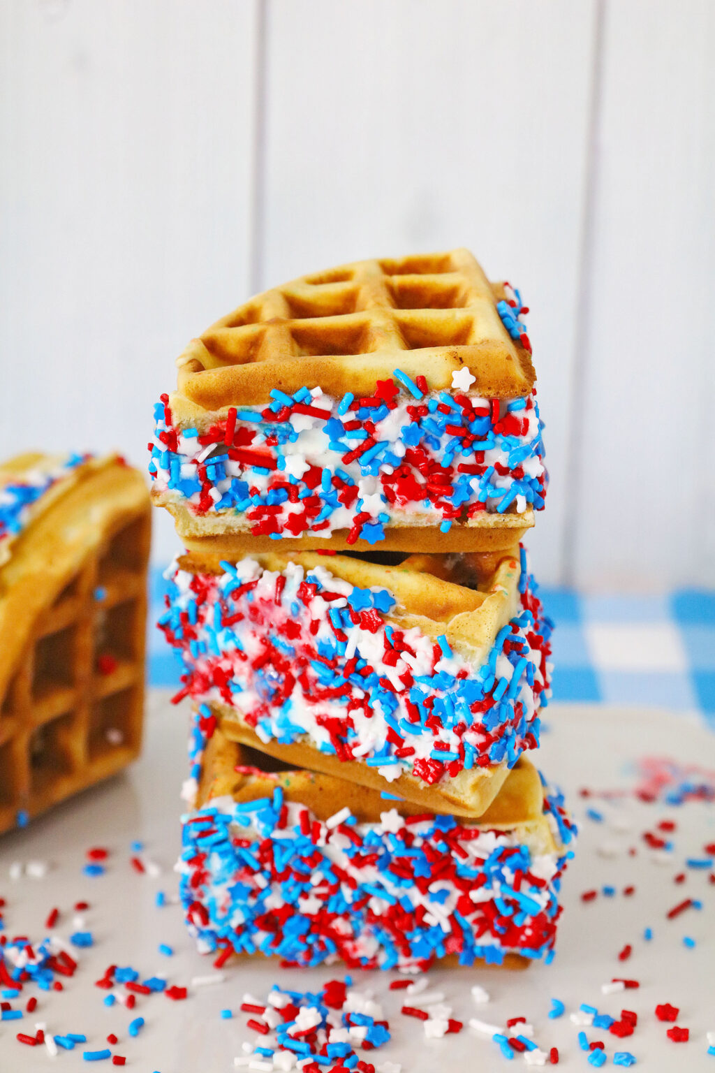 waffle ice cream sandwiches with patriotic sprinkles stacked on top of each other