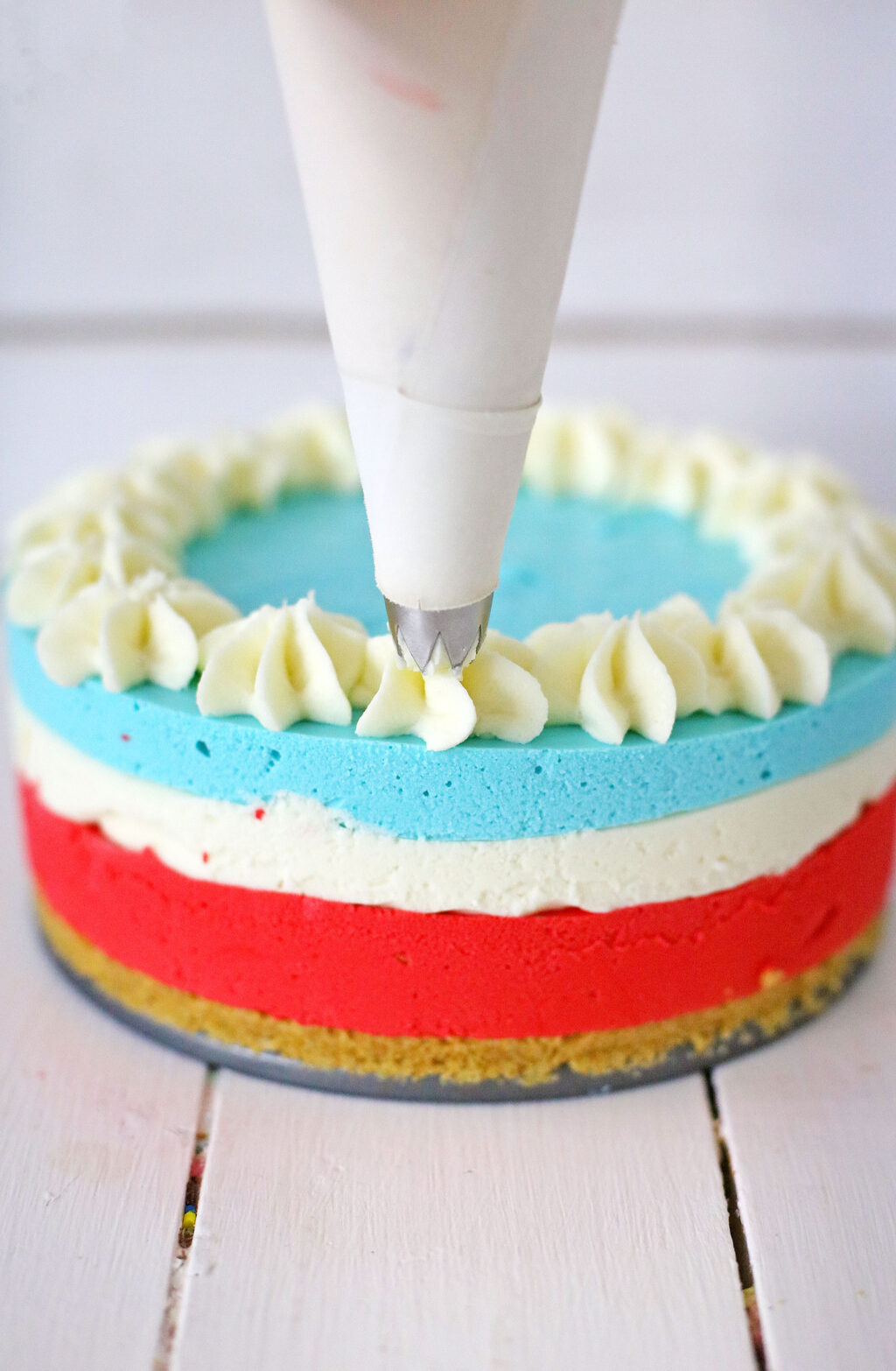 piping frosting on top of cheesecake