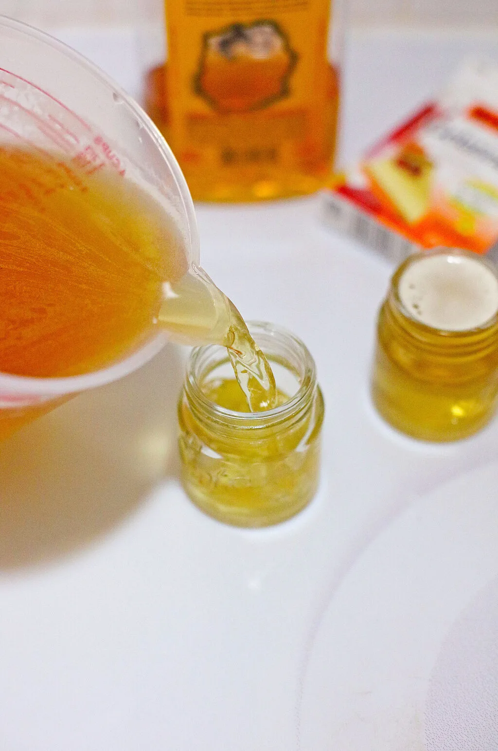 filling mini mason jars with jello shot mixture