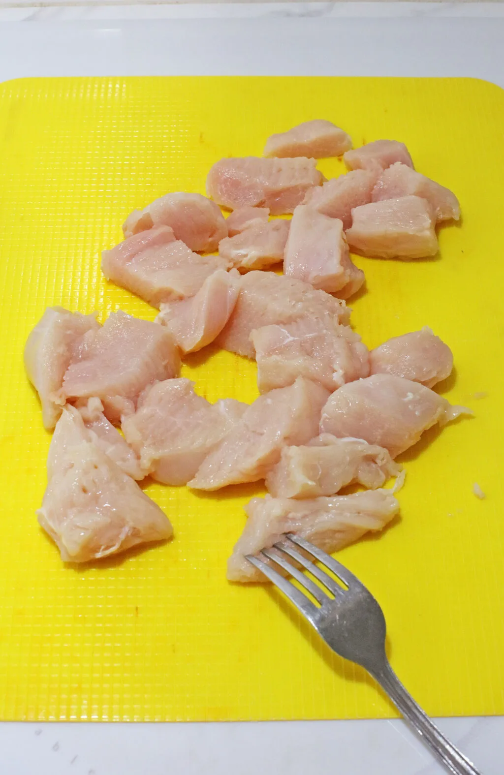 raw chicken pieces on cutting board