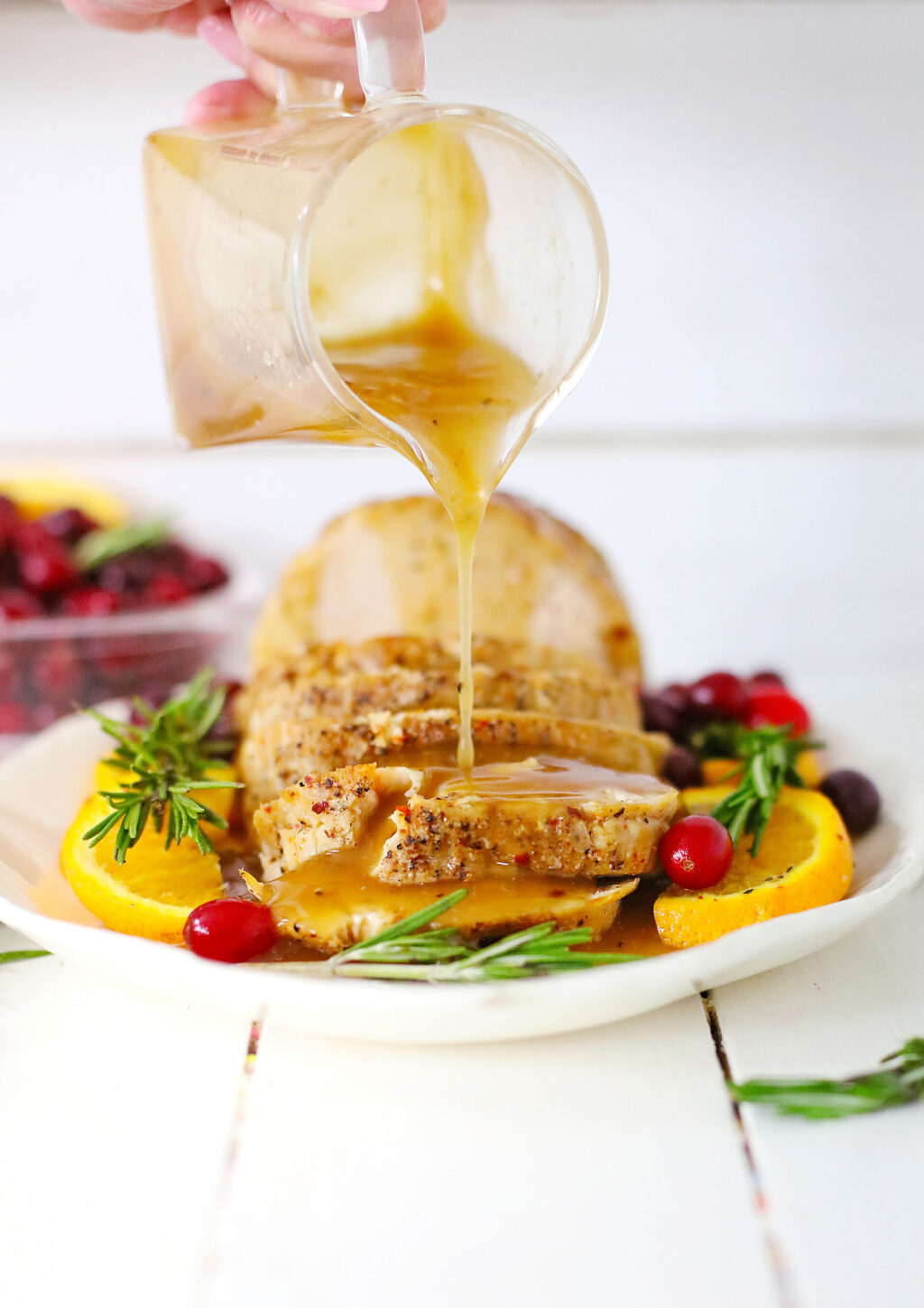 gravy being poured onto crockpot turkey breast on a serving platter