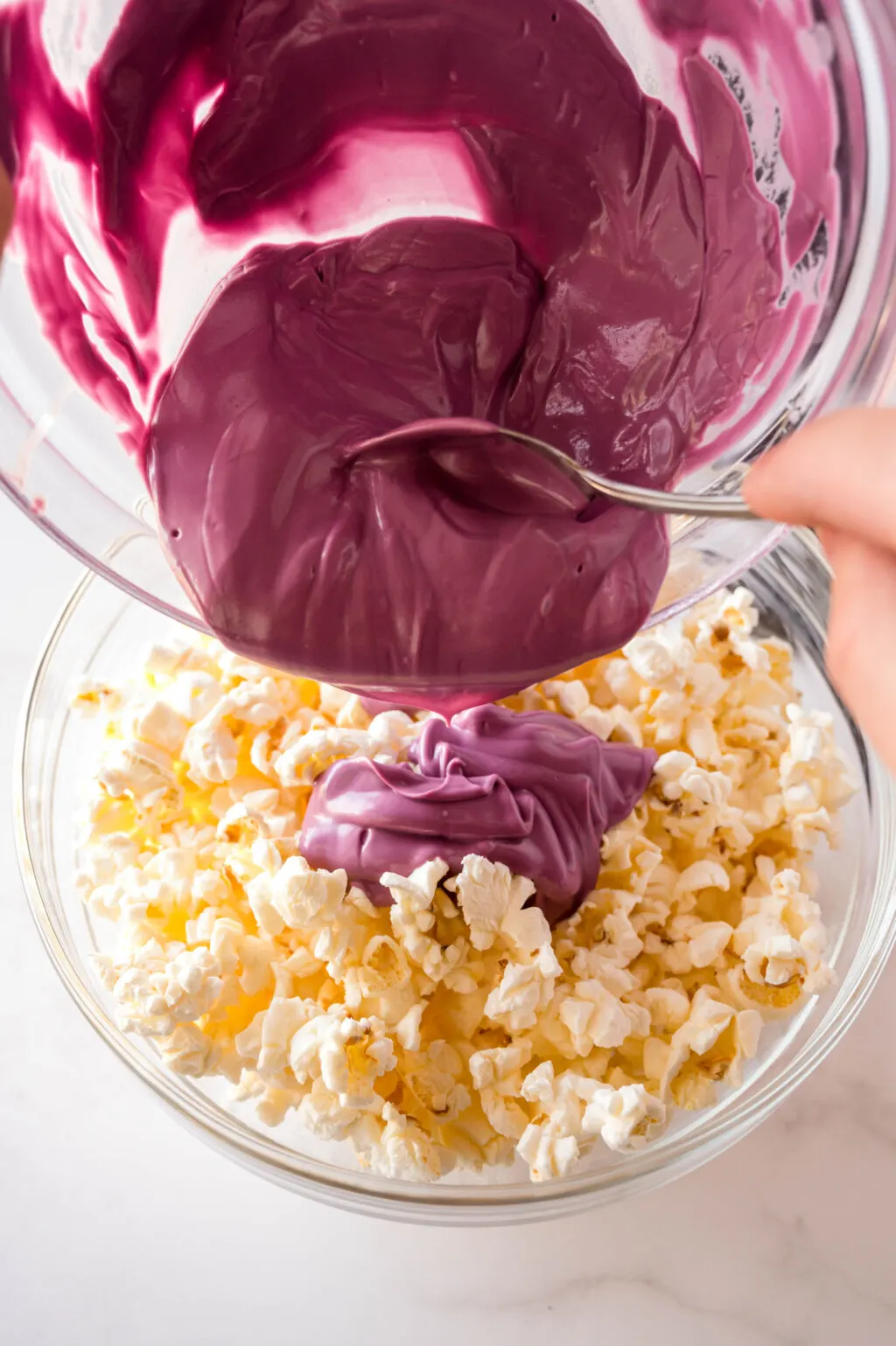 melted purple candy melts poured over popped popcorn