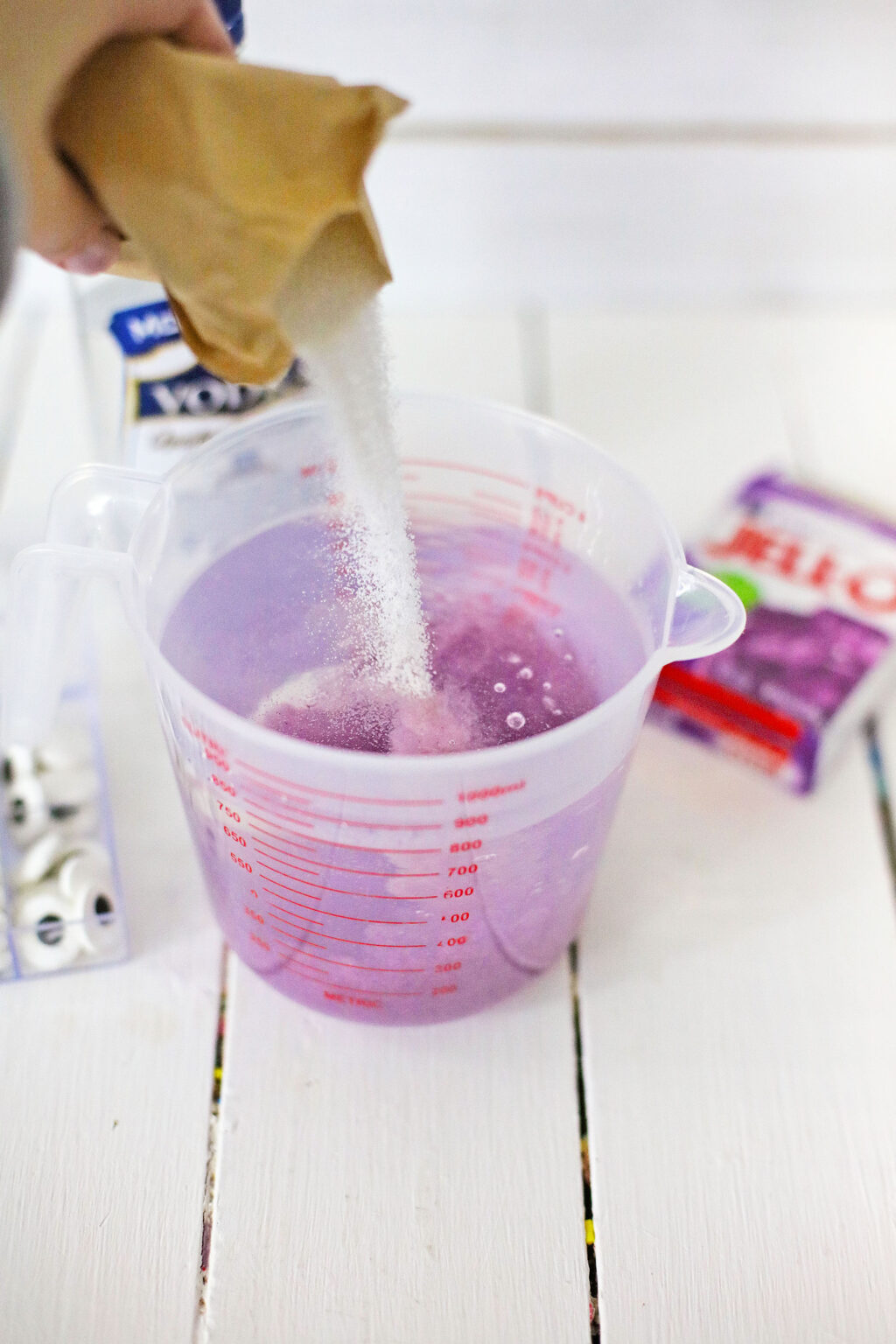 purple jello mix being poured into water