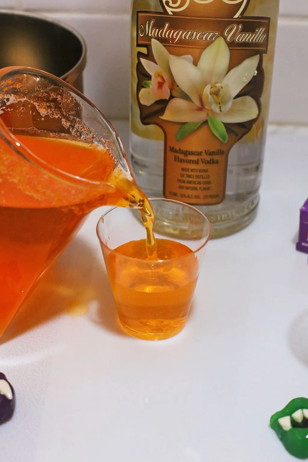 pouring jello shot mixture into jello shot cups