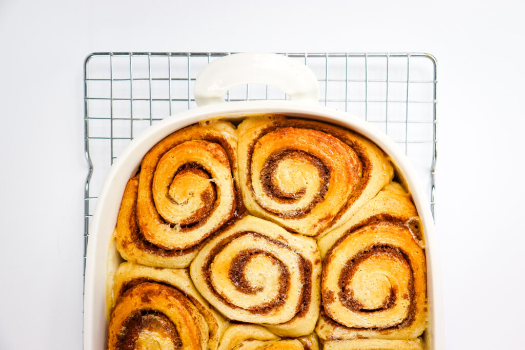 cooked cinnamon rolls in white pan