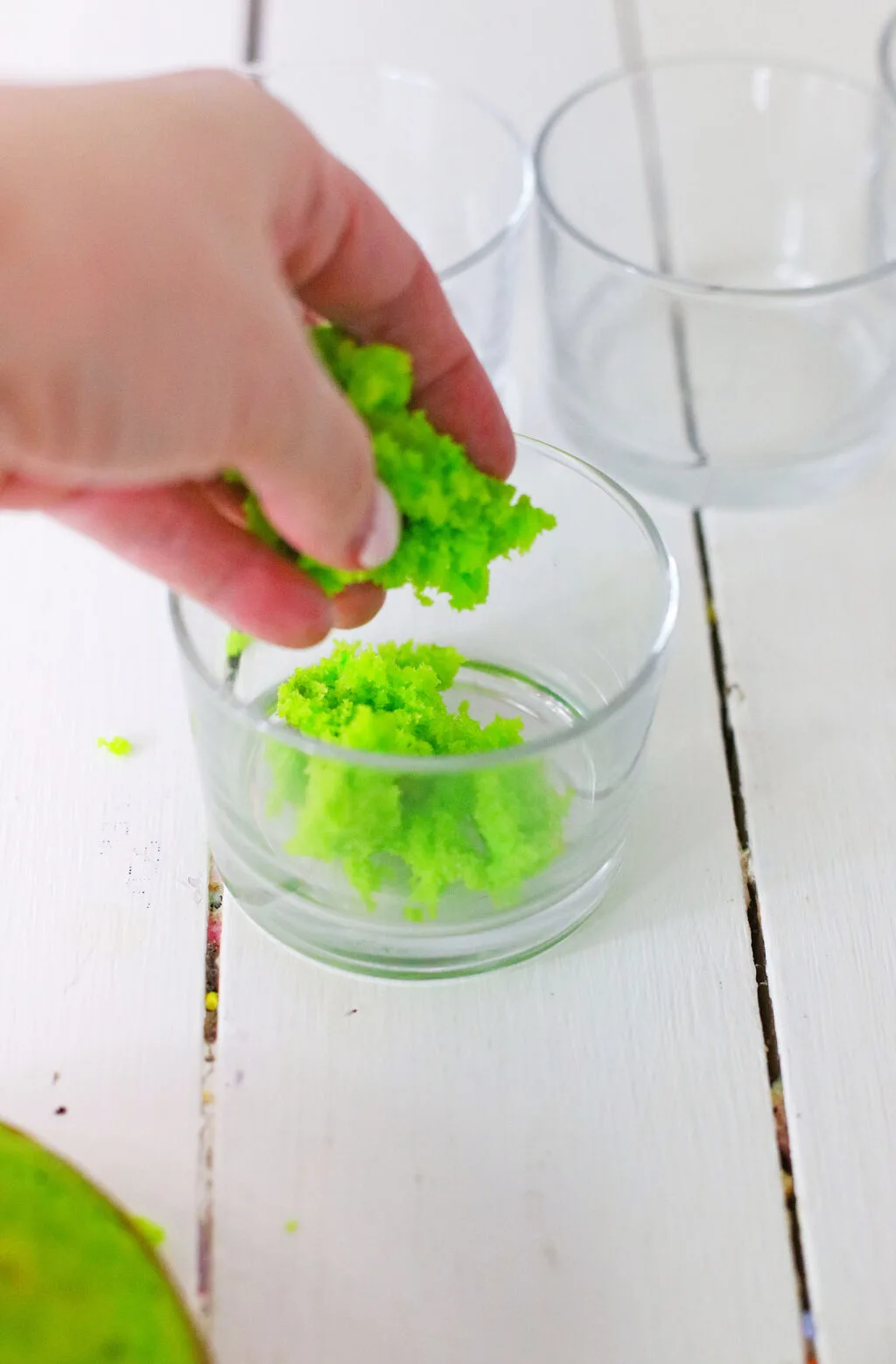 crumbled green cake being put into serving bowl