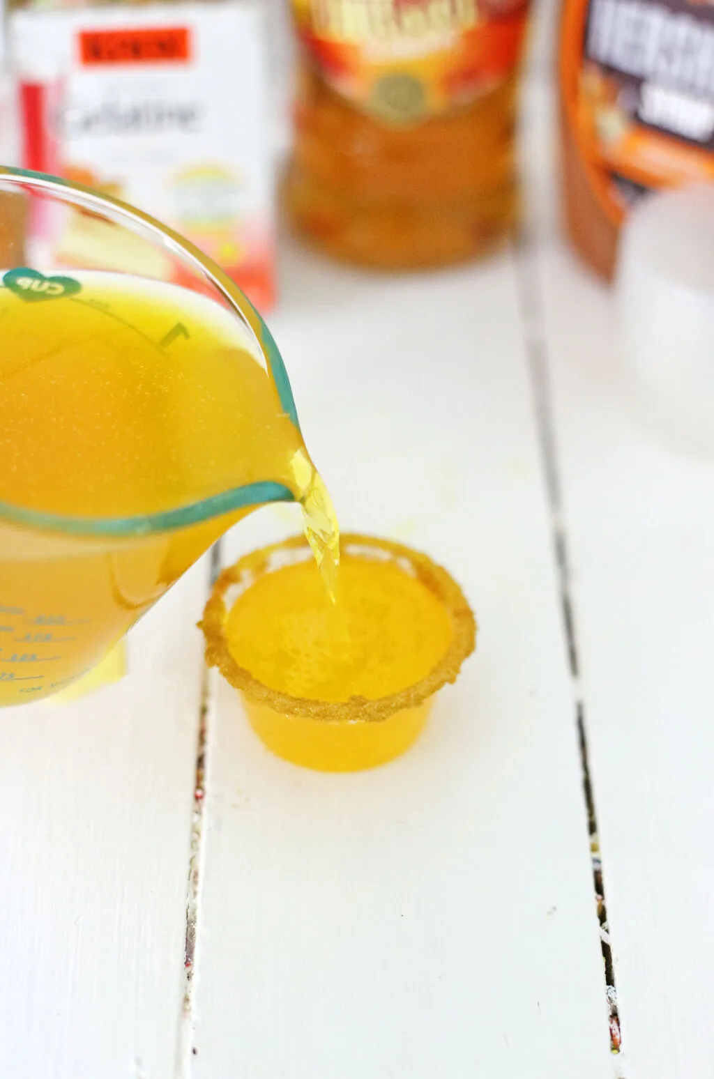 alcoholic jello shot mixture being poured into shot glasses