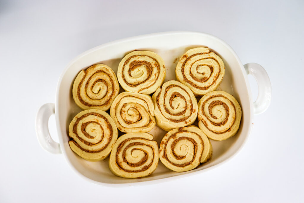raw cinnamon rolls placed into baking dish