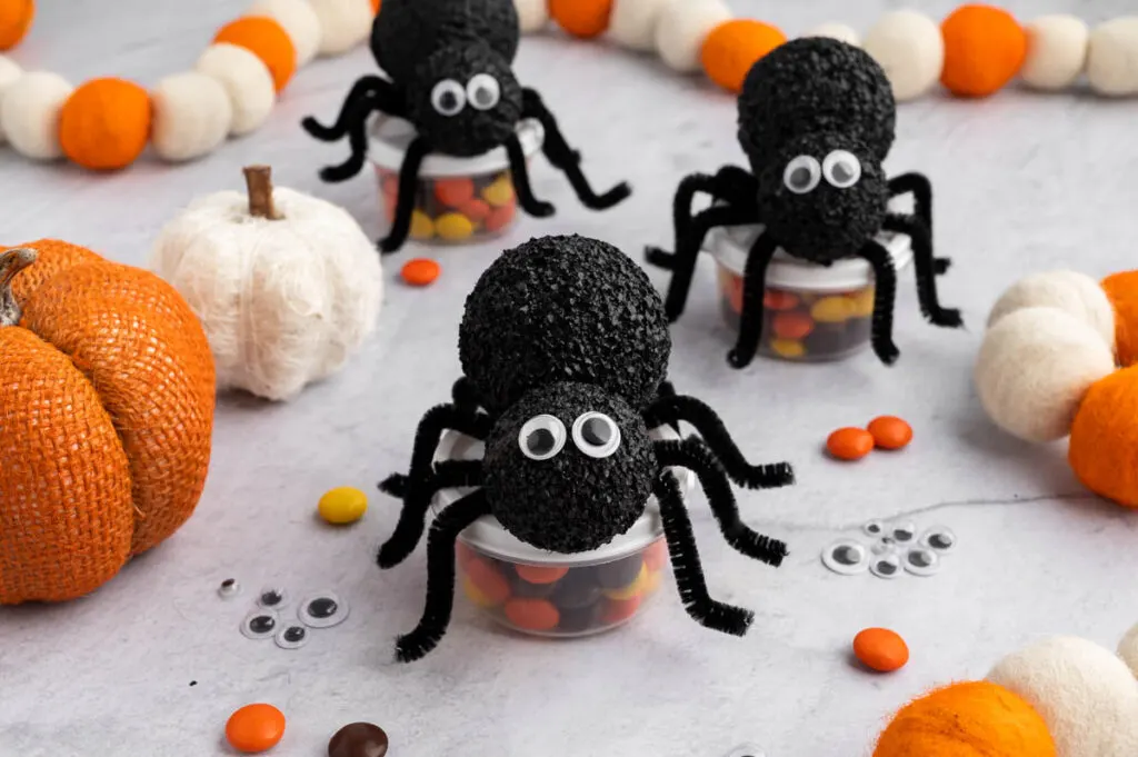 spider treat containers filled with candy on table