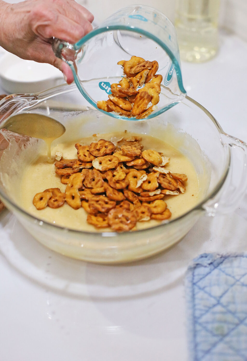 adding pretzel pieces to large bowl of melted sugar
