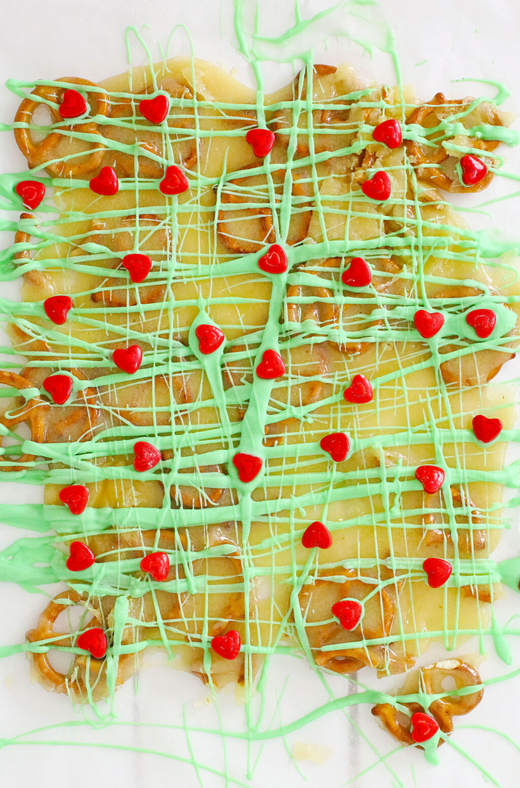 melted green chocolate drizzled over brittle on white table