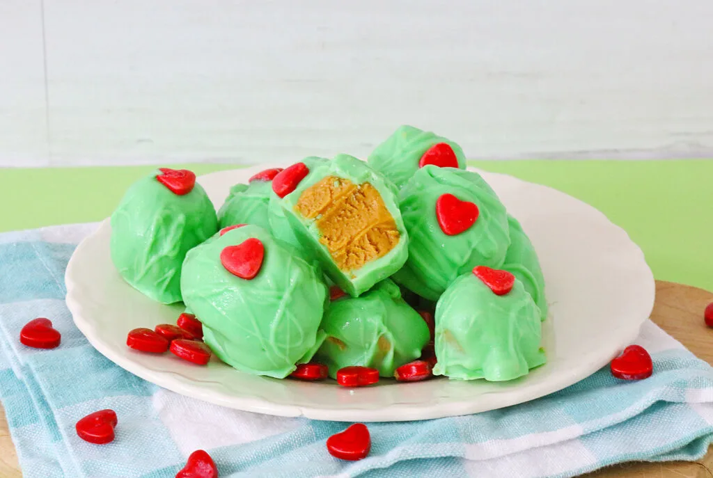 stack of grinch peanut butter balls on white plate