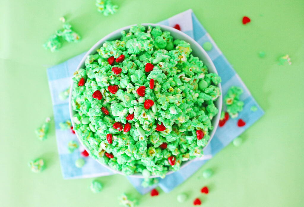 grinch popcorn in large white bowl with blue napkin