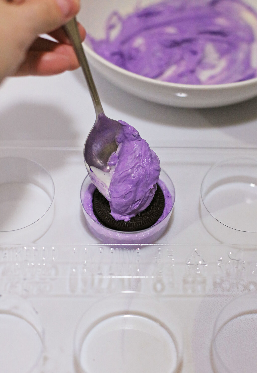 oreo cookie in mold with melted purple chocolate