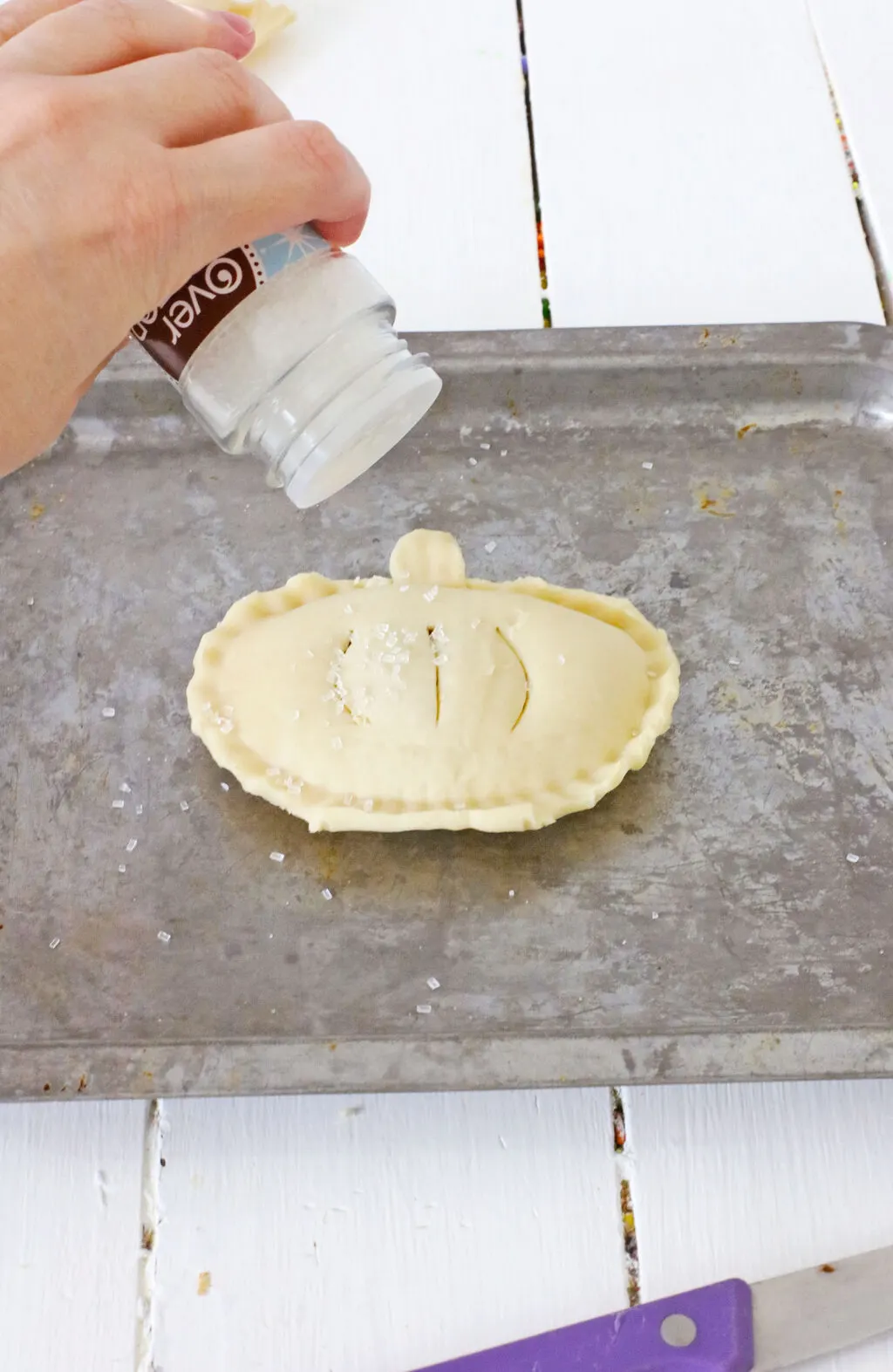 sugar sprinkled on top of uncooked pumpkin hand pies