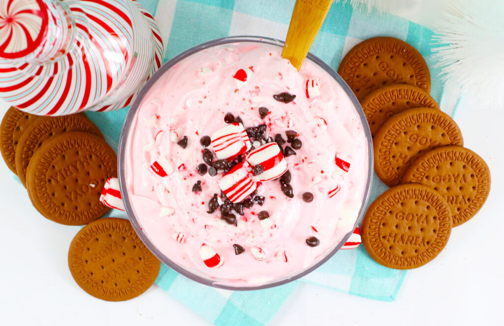 bowl of boozy peppermint dip on a blue plaid napkin with gingerbread cookies next to it
