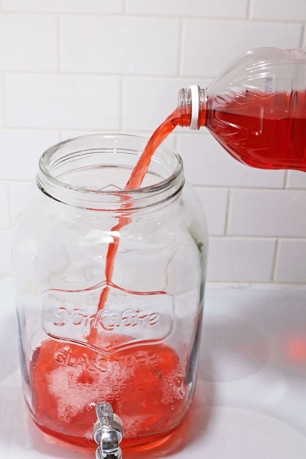 pouring juice for christmas punch into large container