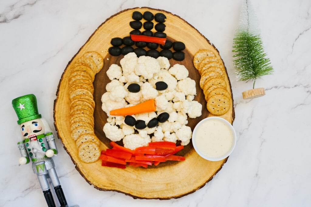 snowman veggie tray with red peppers on it