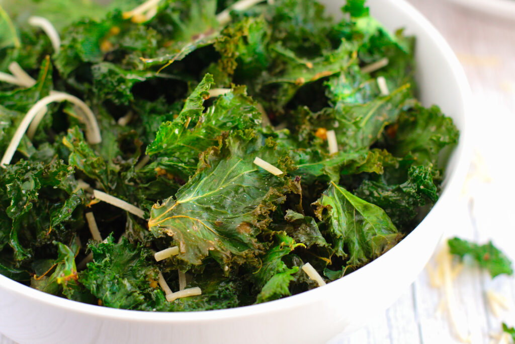 crispy kale chips in a white bowl on a table