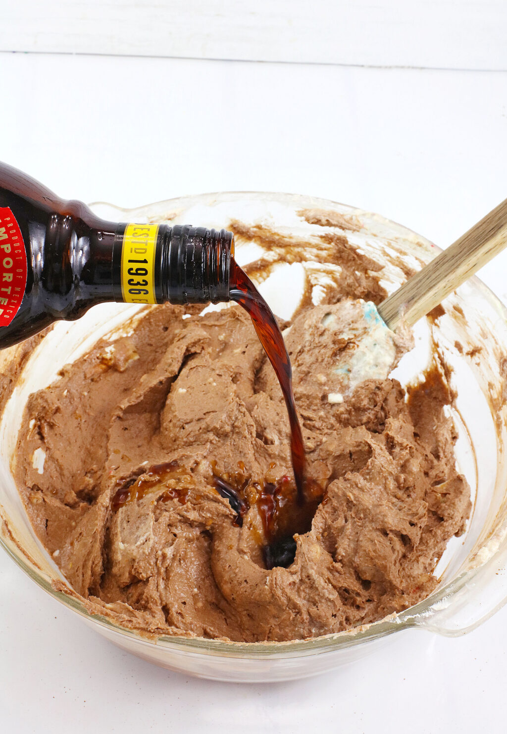 hand pouring Kahlua into bowl with dip