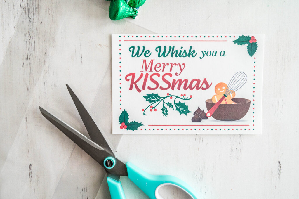 we whisk you a merry kissmas gift tag with scissors on table