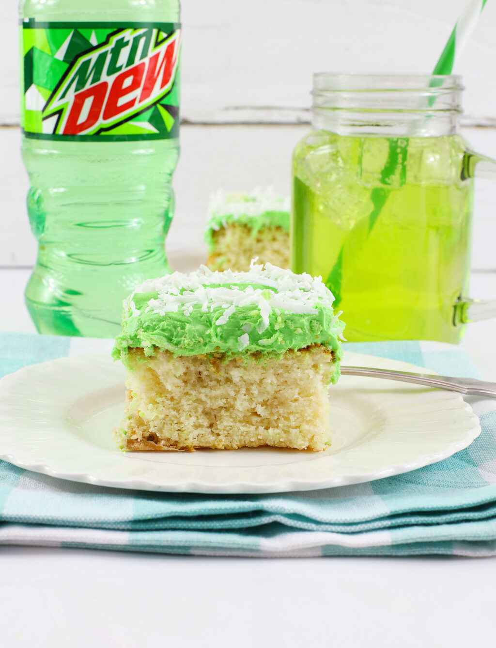 slice of mountain dew cake with mtn dew in the glass