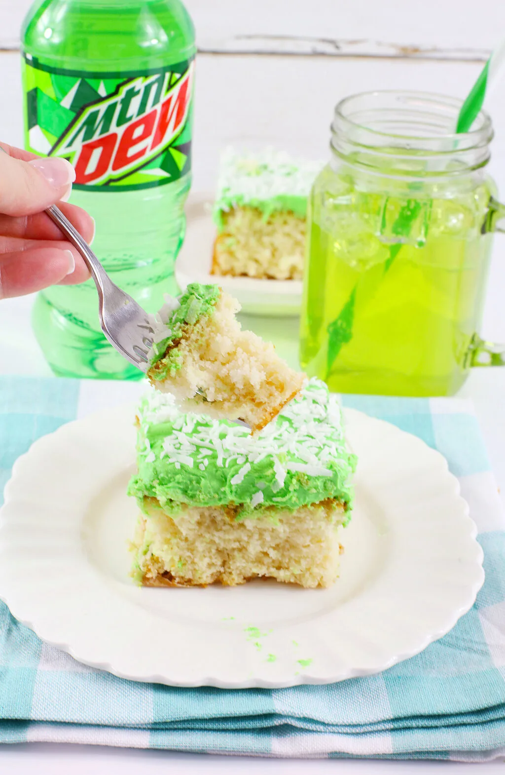 woman's hand holding fork with a bite of mountain dew cake on it