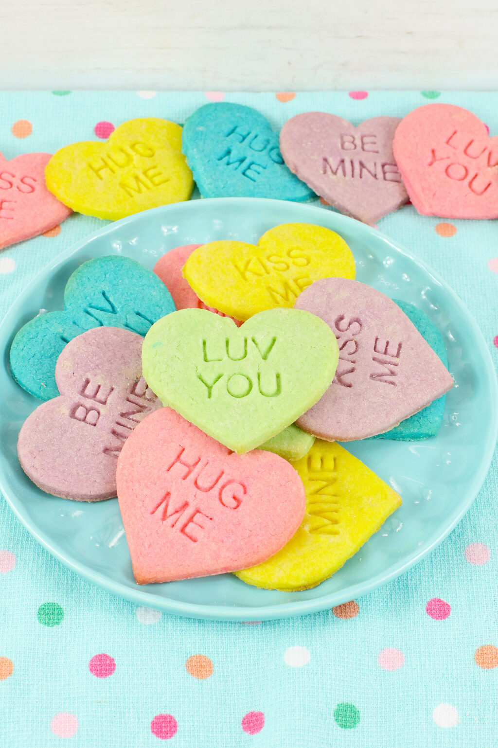 blue plate with colorful conversation heart sugar cookies on it