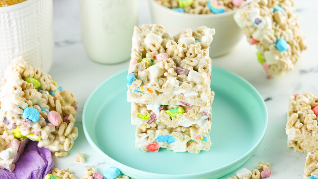 square pieces of lucky charms rice krispie treats on aqua plate