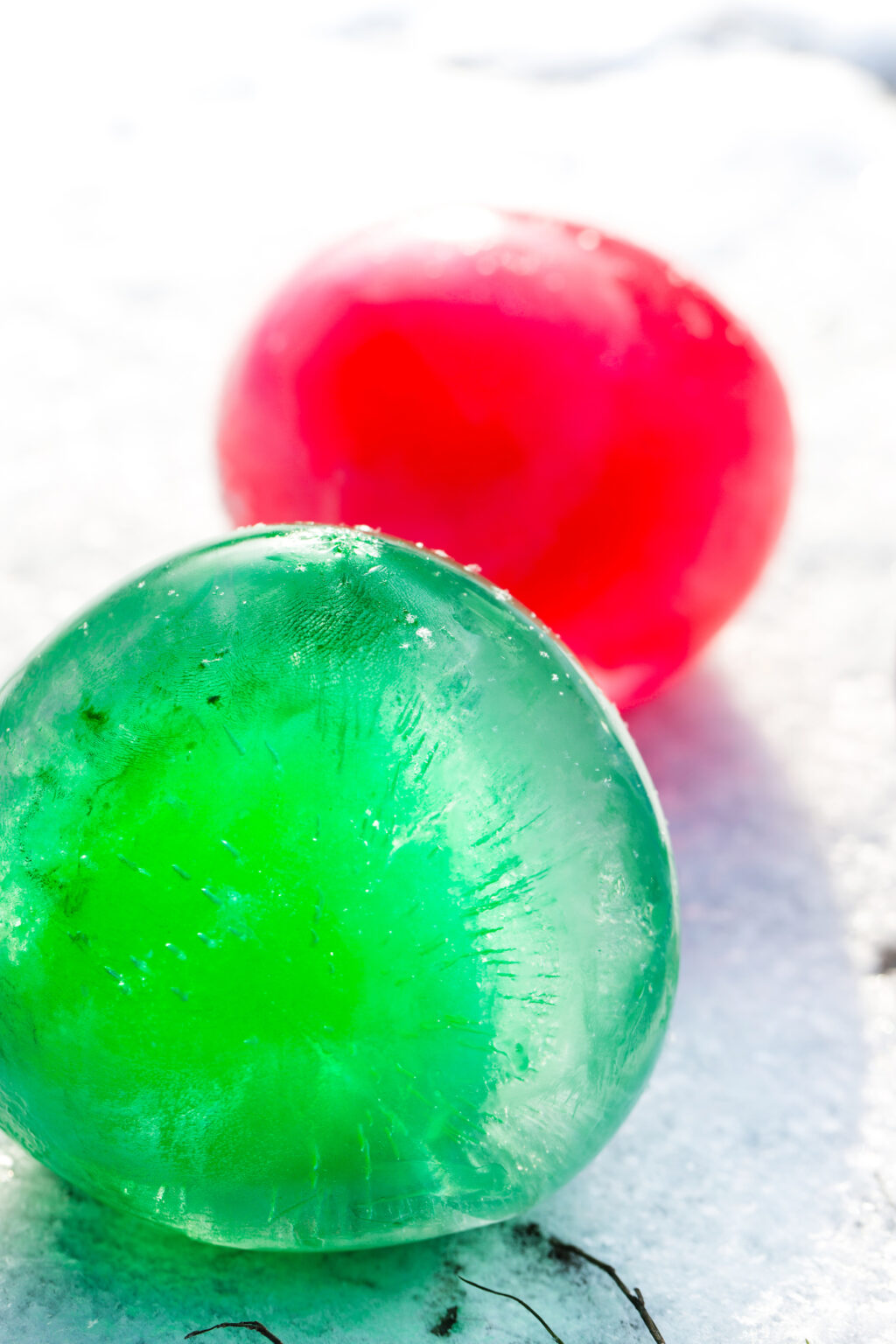 green and red ice marbles outside on snow