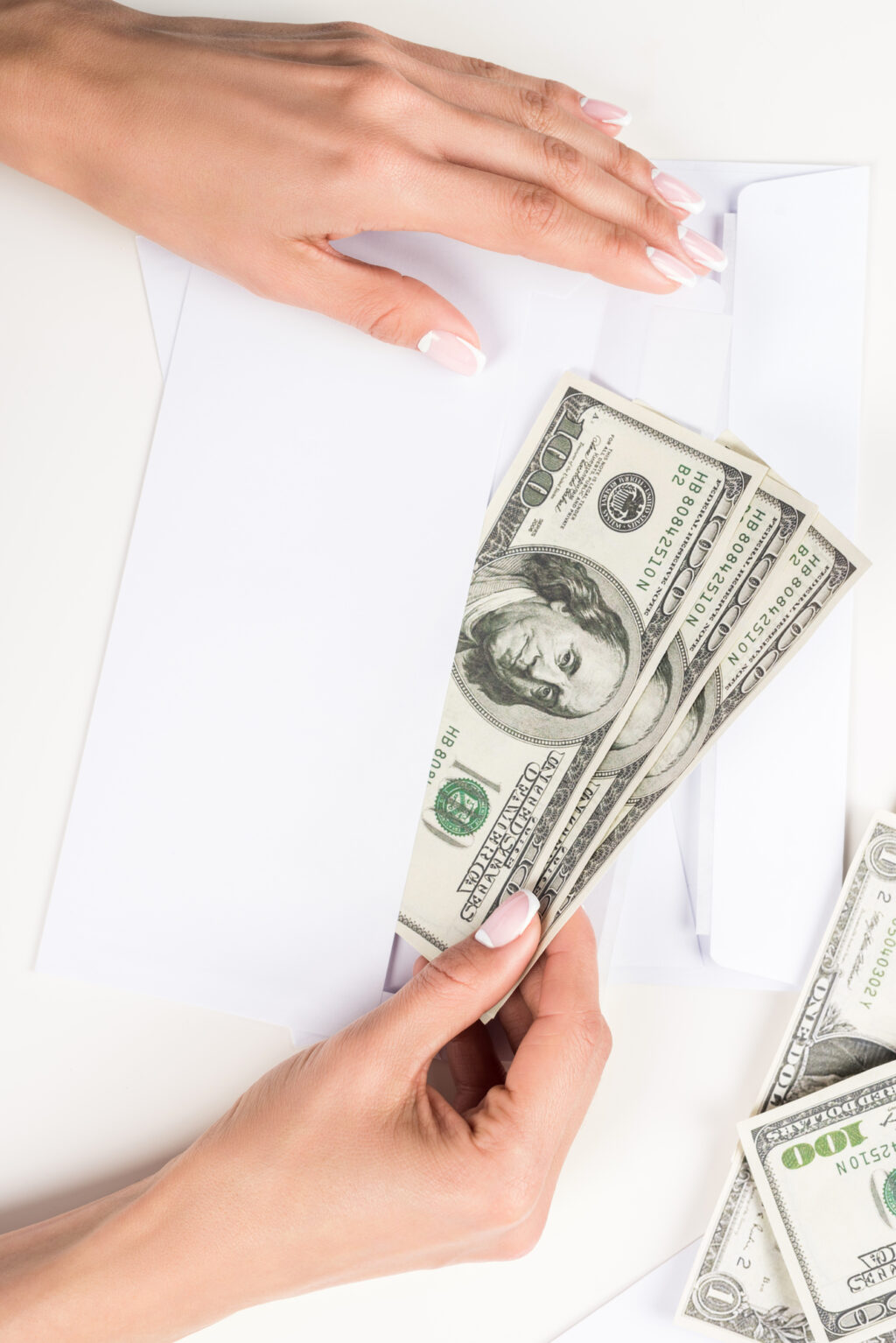 woman stuffing white envelope with money