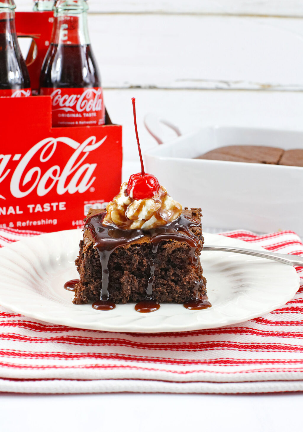 slice of 2 ingredient coke cake on white plate with red napkin