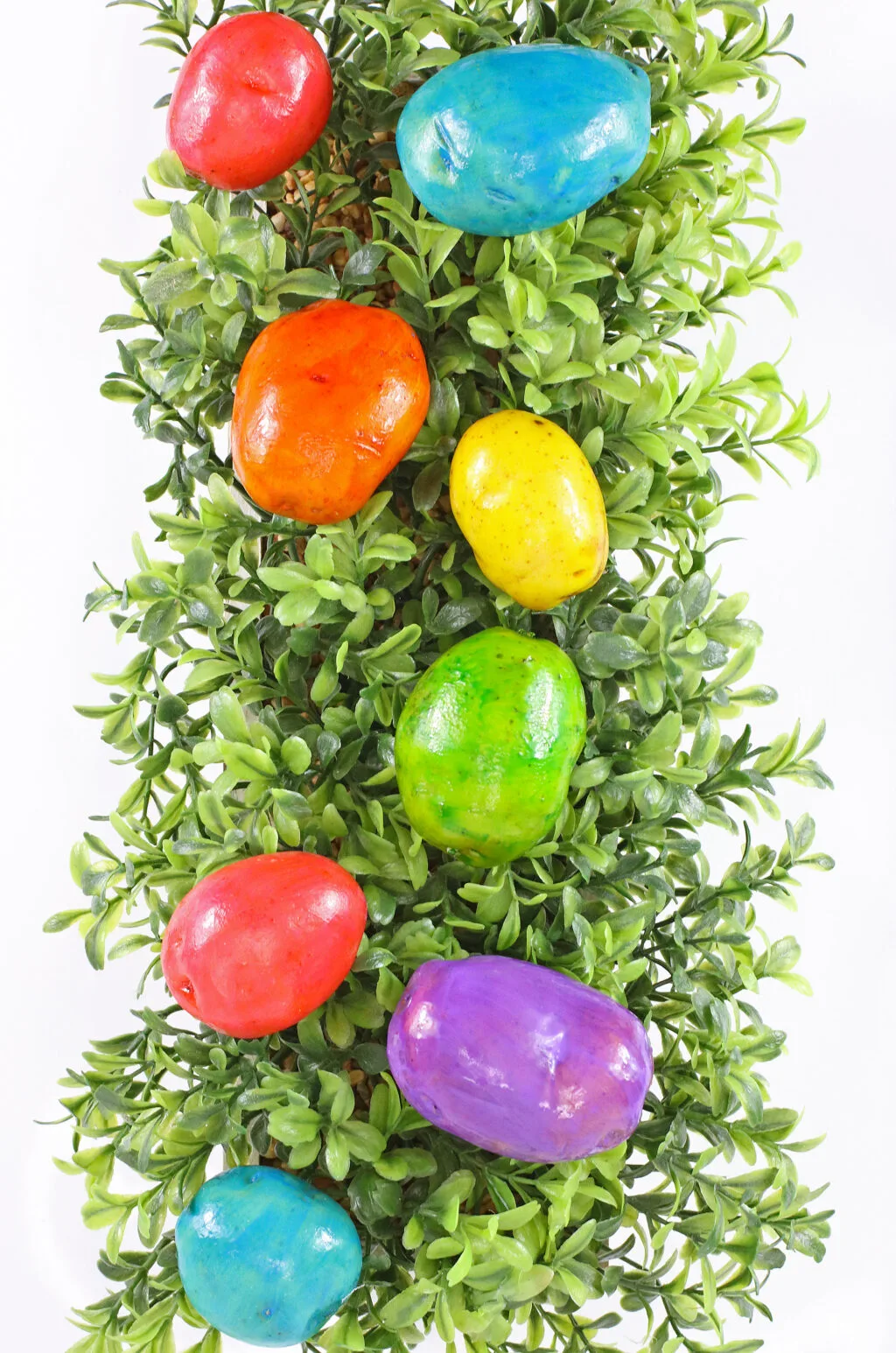 easter egg dyed potatoes on green grass background