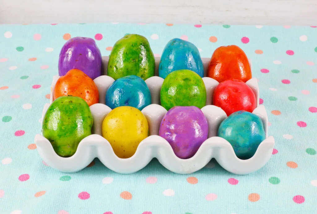 vibrant colored easter potatoes in a white egg tray