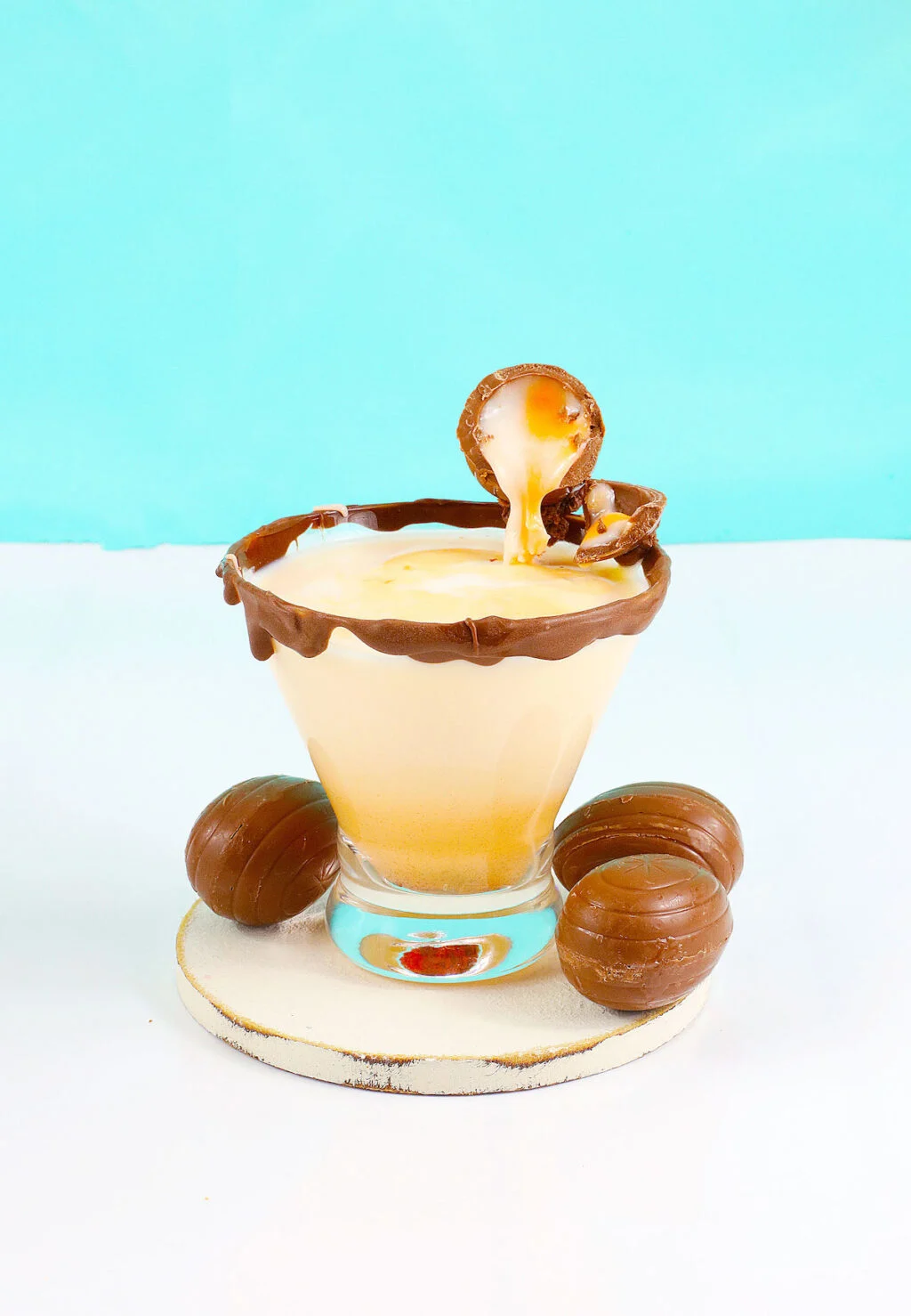 cadbury creme egg cocktail on white table with blue background