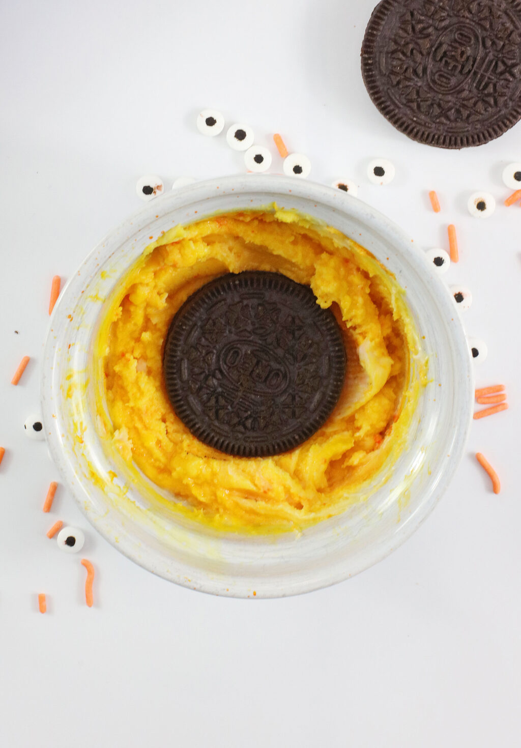 dipping oreo into melted yellow chocolate