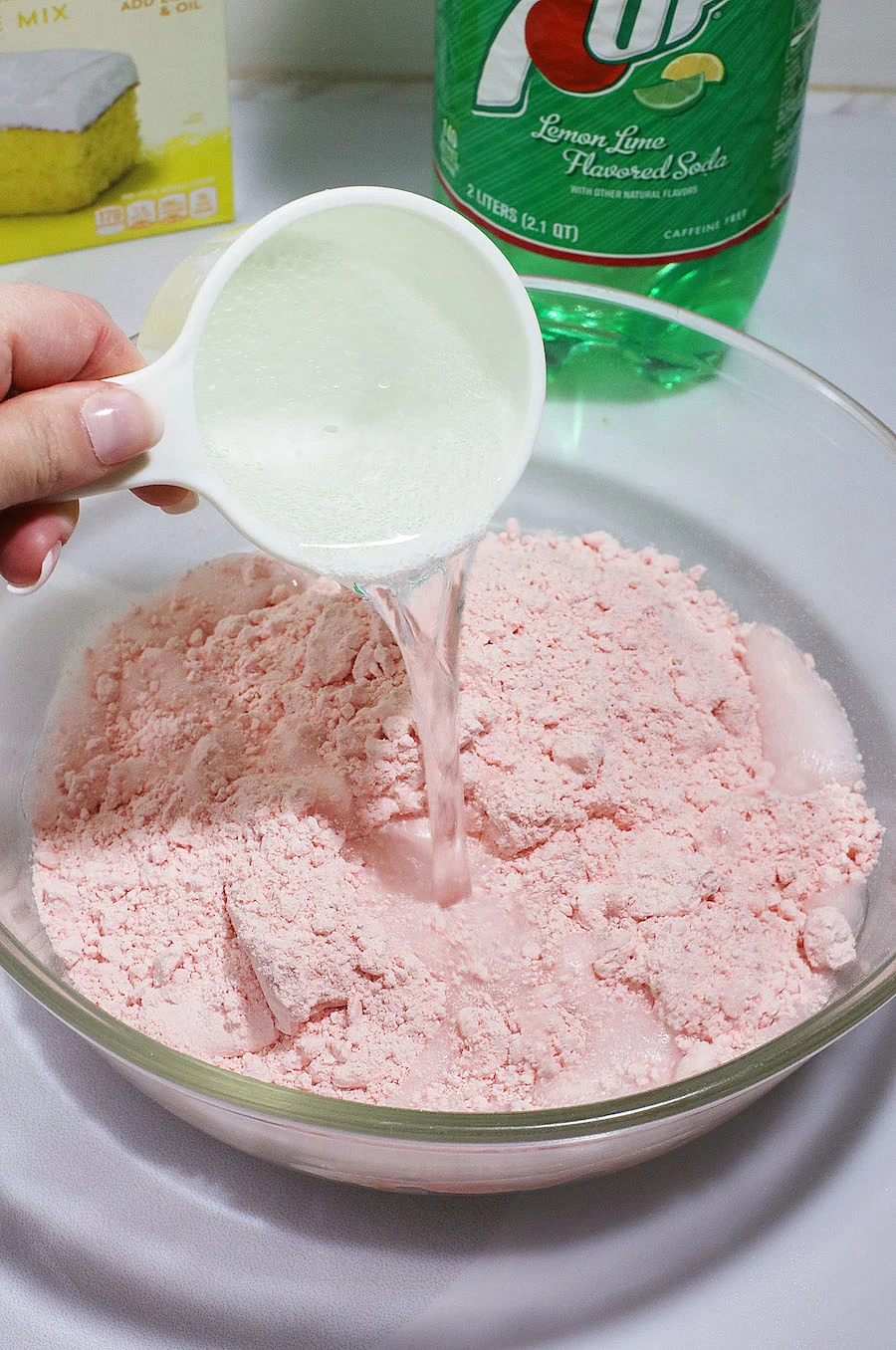 sprite being poured into strawberry cake mix bowl