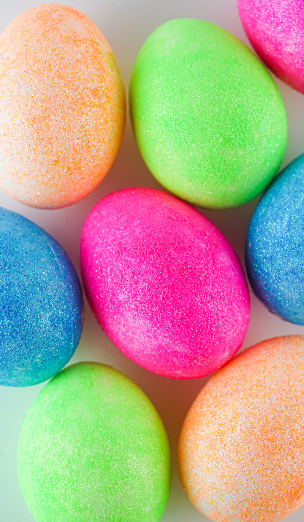 colorful glitter easter eggs on white table