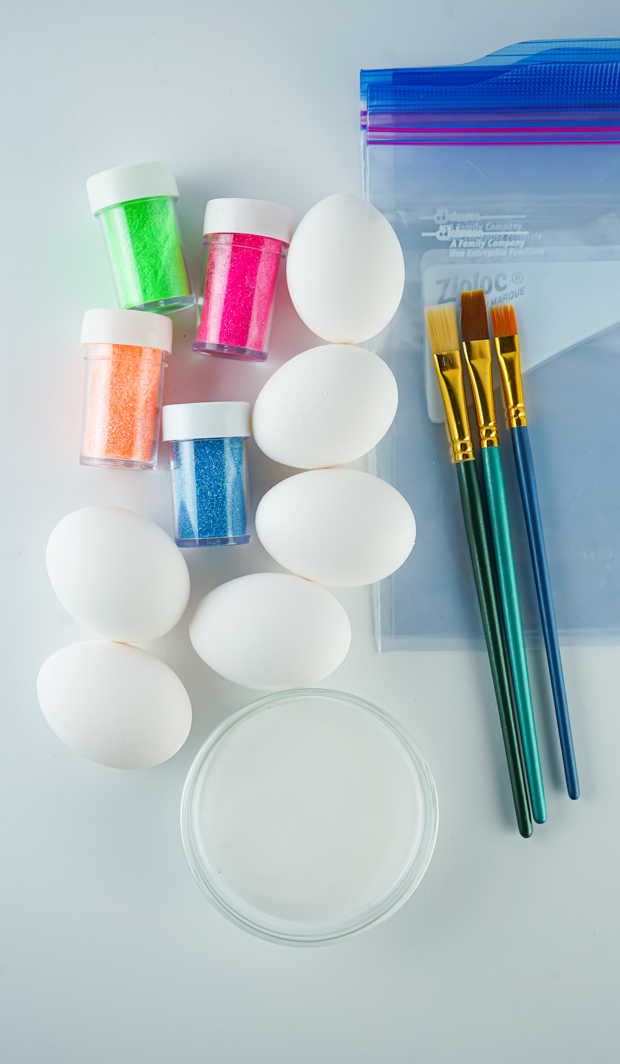 glitter easter egg supplies on white table