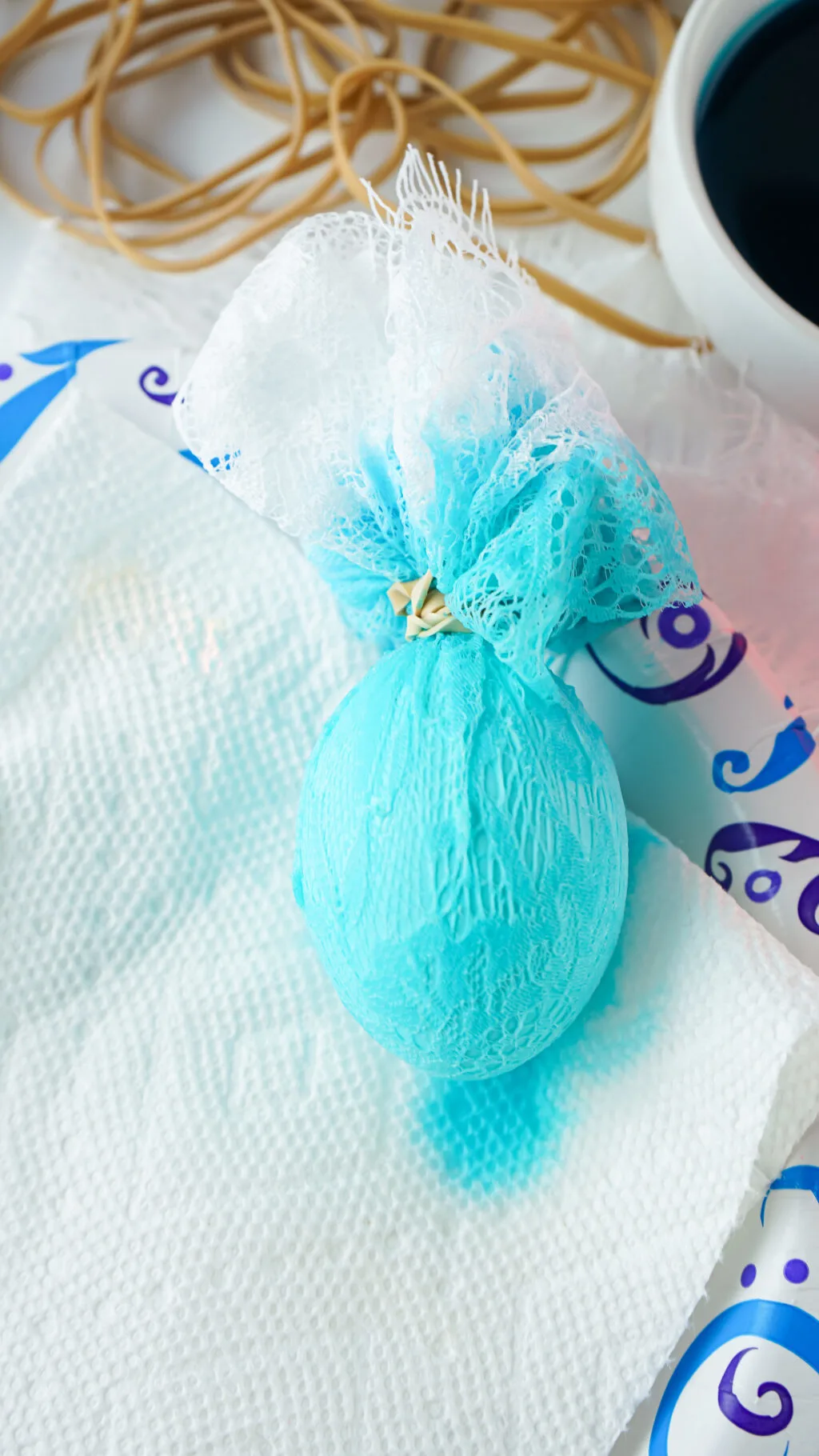 blue dyed fabric egg sitting on paper towels to dry