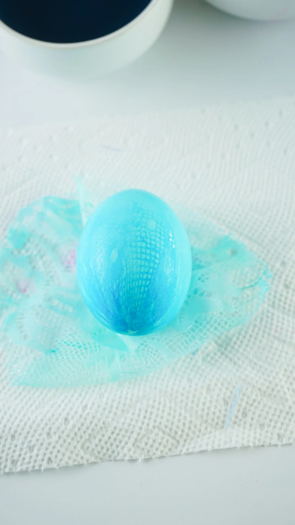 blue fabric dyed easter egg drying on paper towels