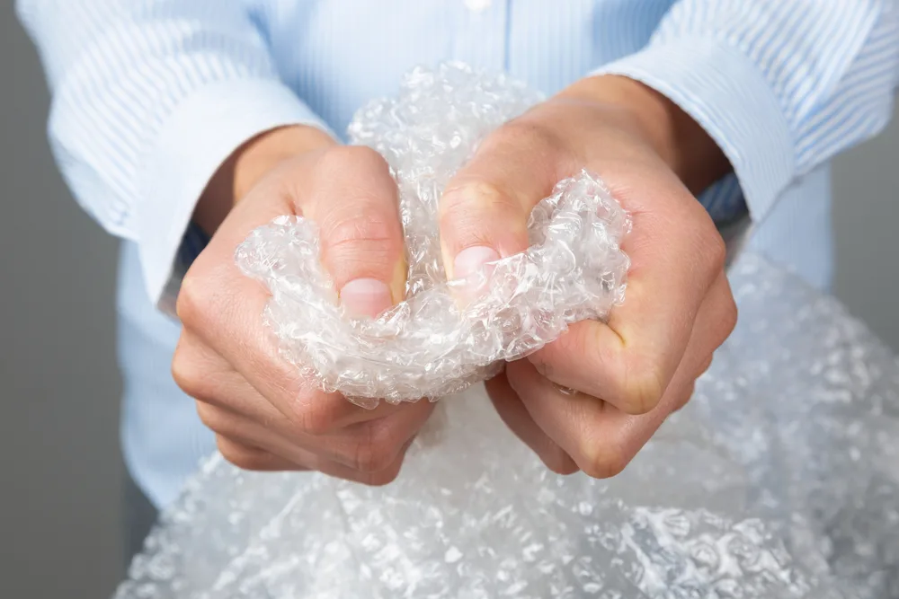 hands popping bubble wrap for april fools day prank