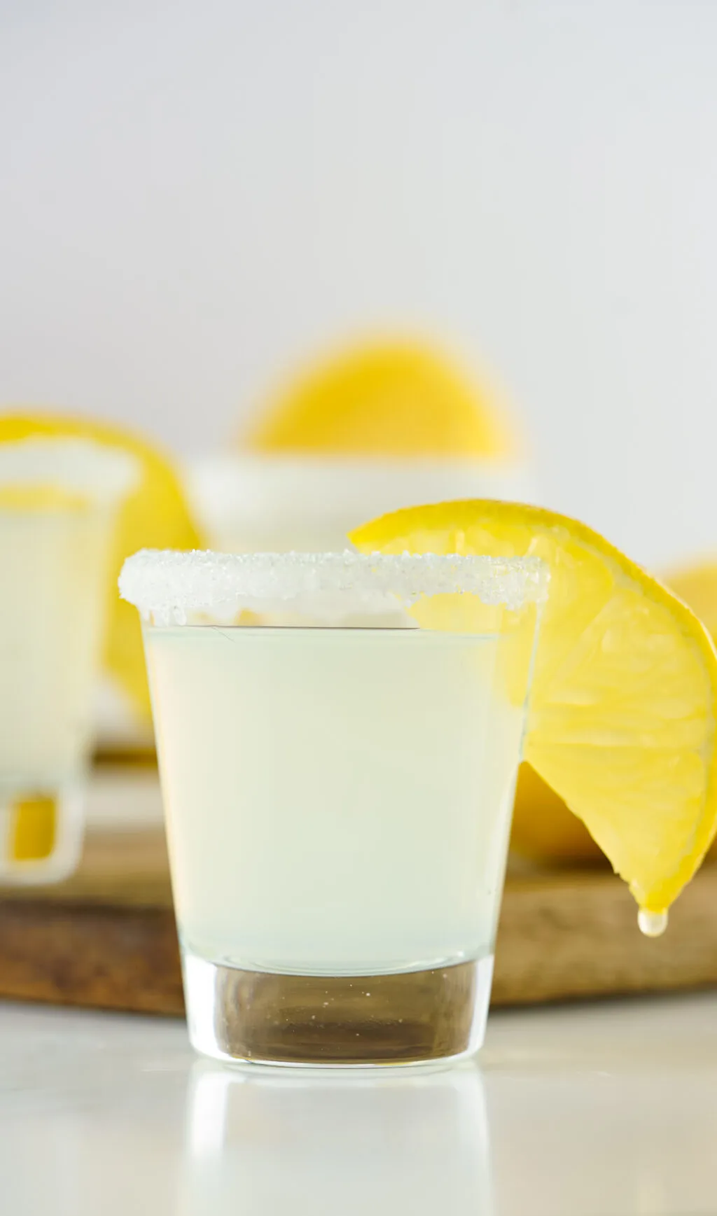 lemon drop shot with lemon dripping on white table