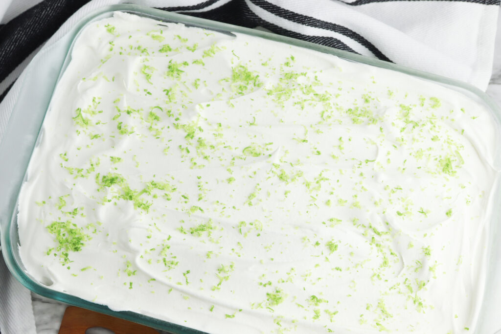 whipped topping on top of key lime poke cake