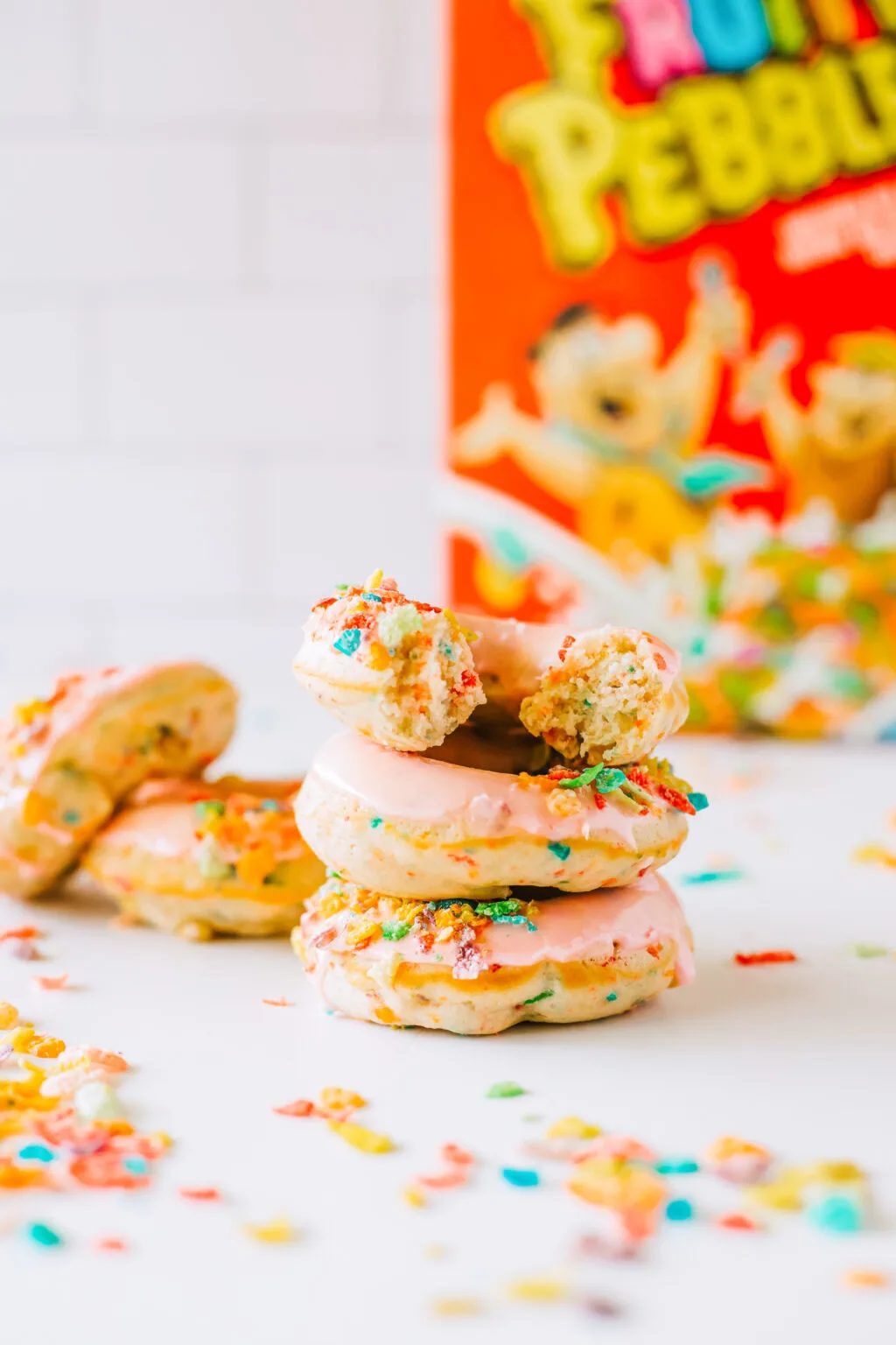 fruity pebbles donuts stacked on white plate