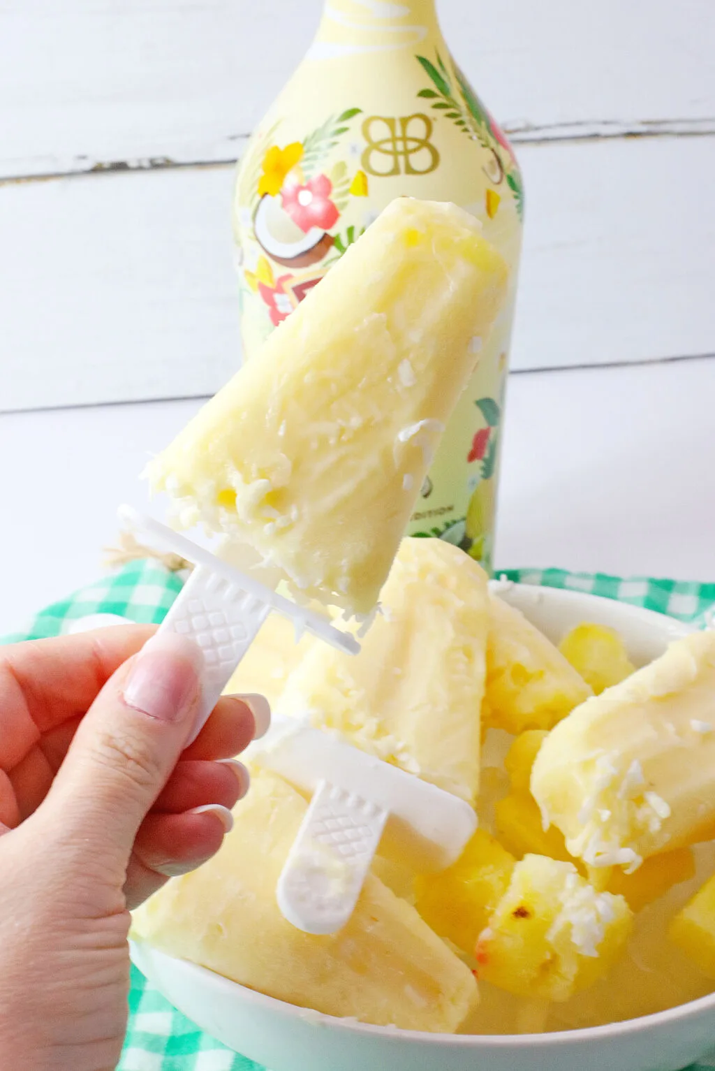 woman's hand holding pina colada popsicle