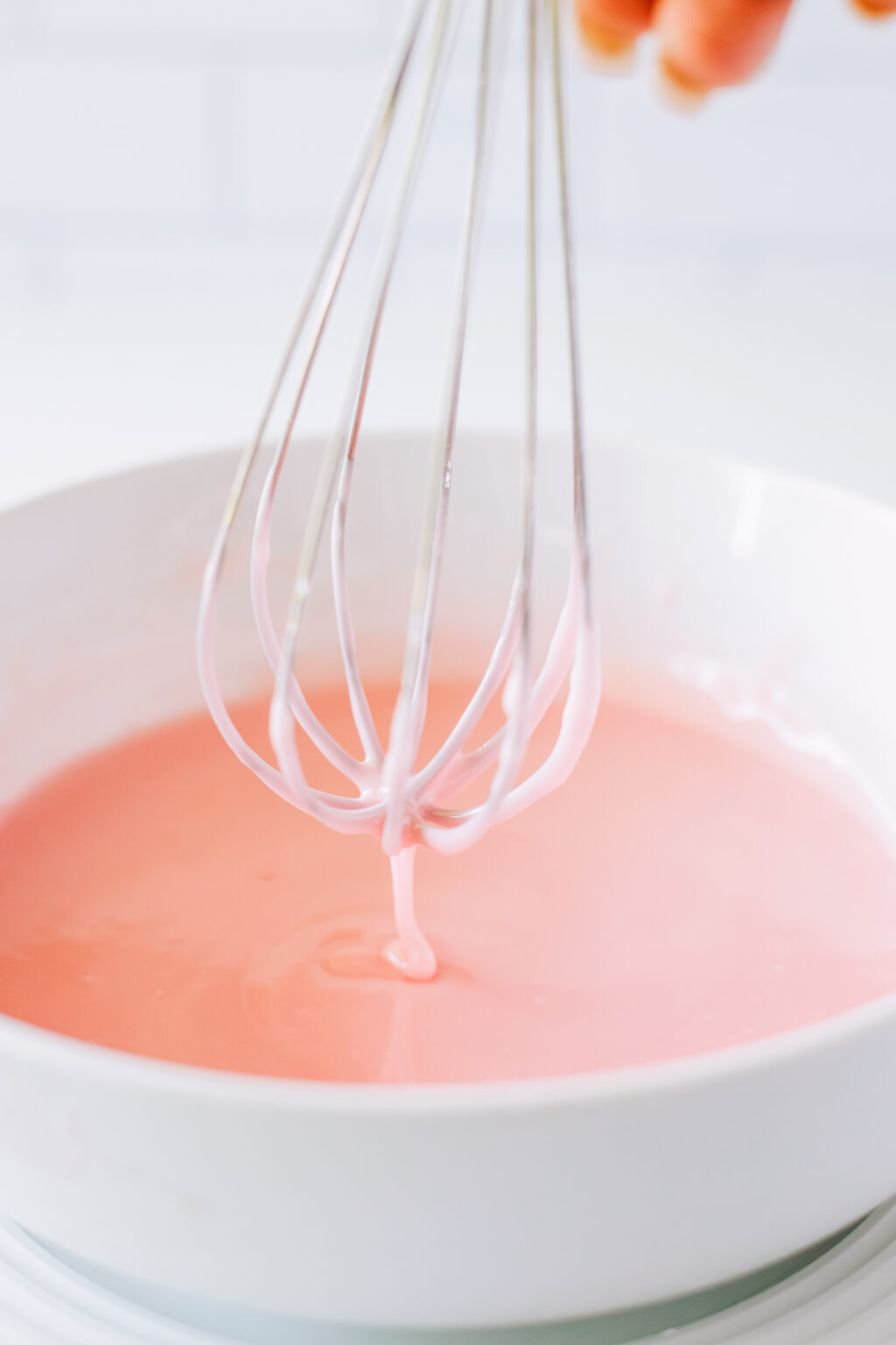 whisk dipped into pink glaze