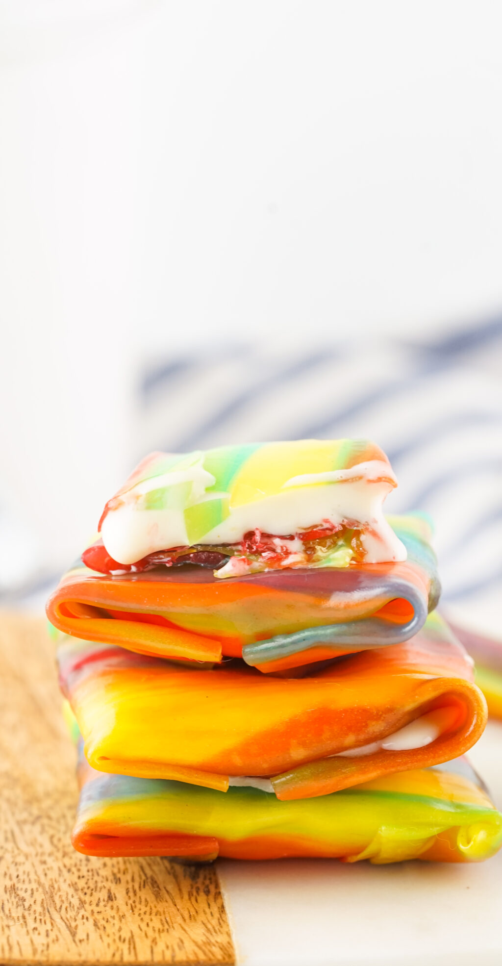 fruit roll ups ice cream stacked on white plate with melted ice cream dripping