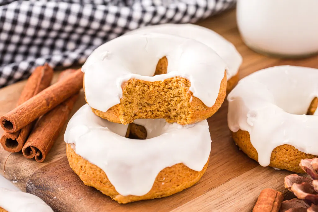 3-ingredient pumpkin donuts on a cutting board with bite taken out of one
